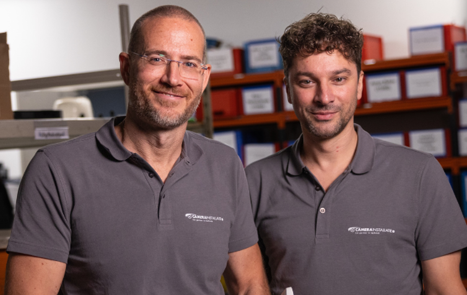 Oprichters Marc en John van CameraInstallatie samen in het magazijn voor de stellingen met onderdelen