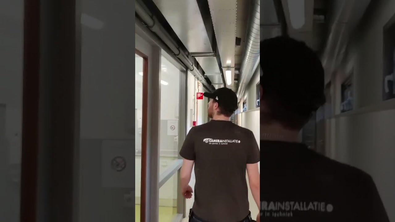 Video: monteur van CameraInstallatie loopt door de gang van het opvangcentrum tijdens de camera-installatie