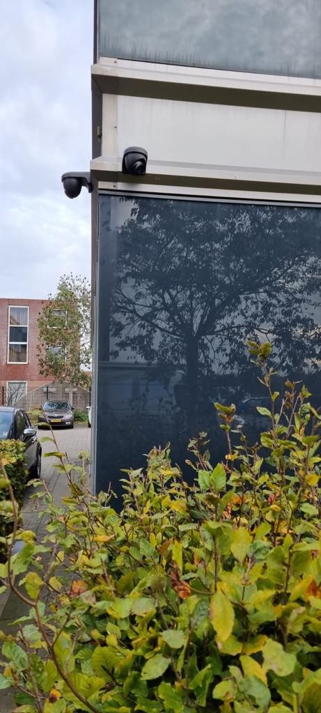 Camera op de buitenhoek van het complex met zicht langs het groen
