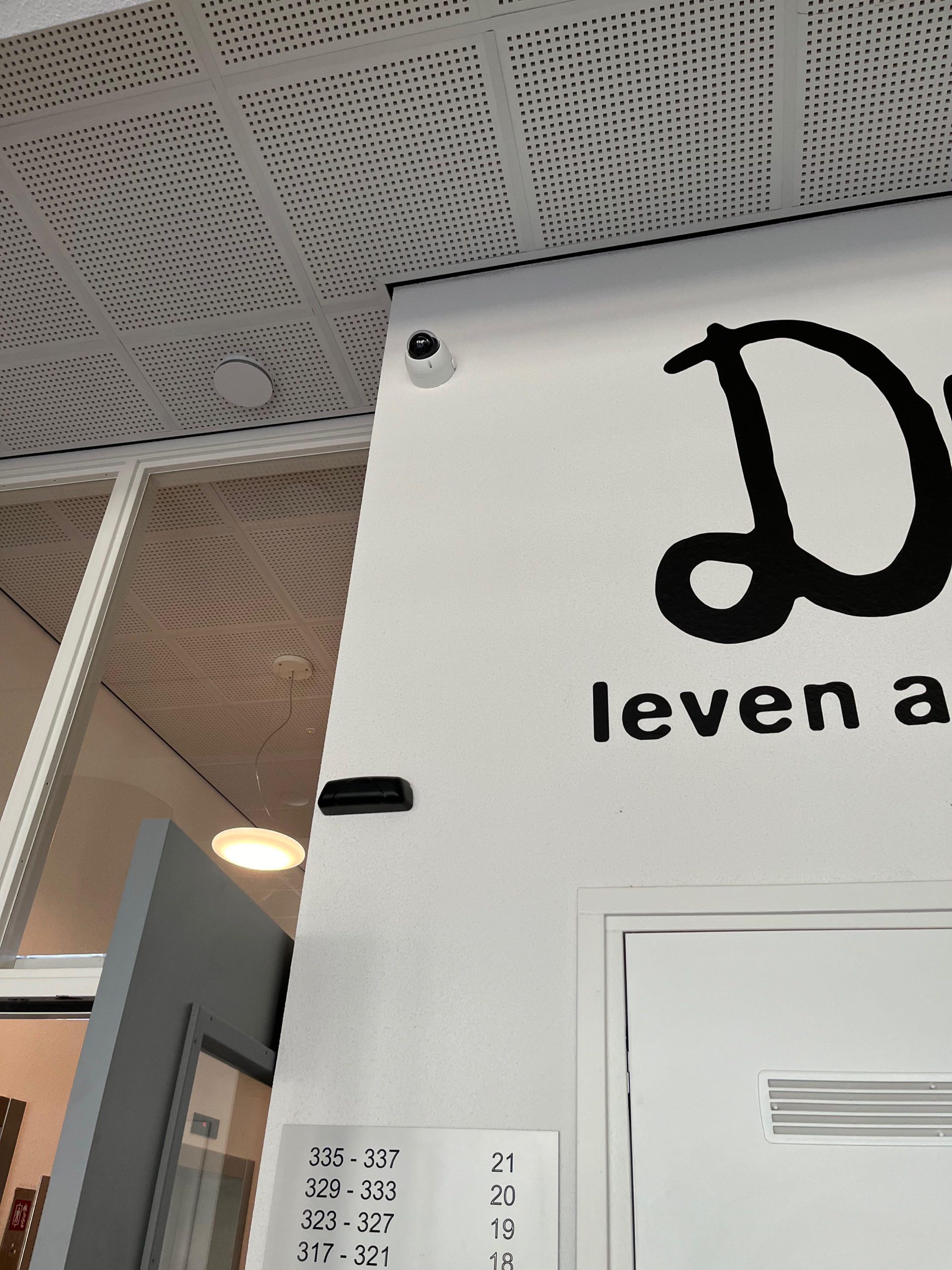 Deur van de bergingsgang met de nummers van de appartementen