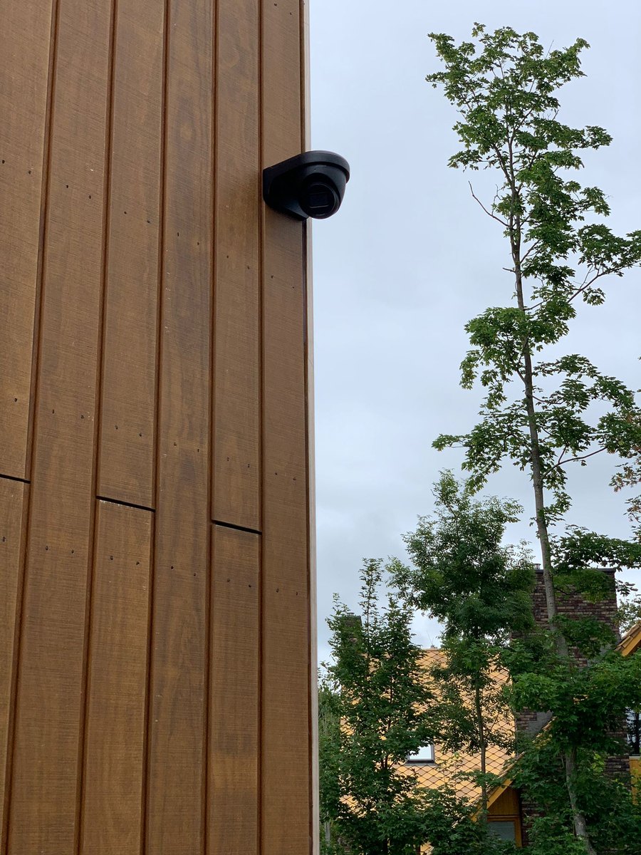 Zwarte camera op een houten gevel