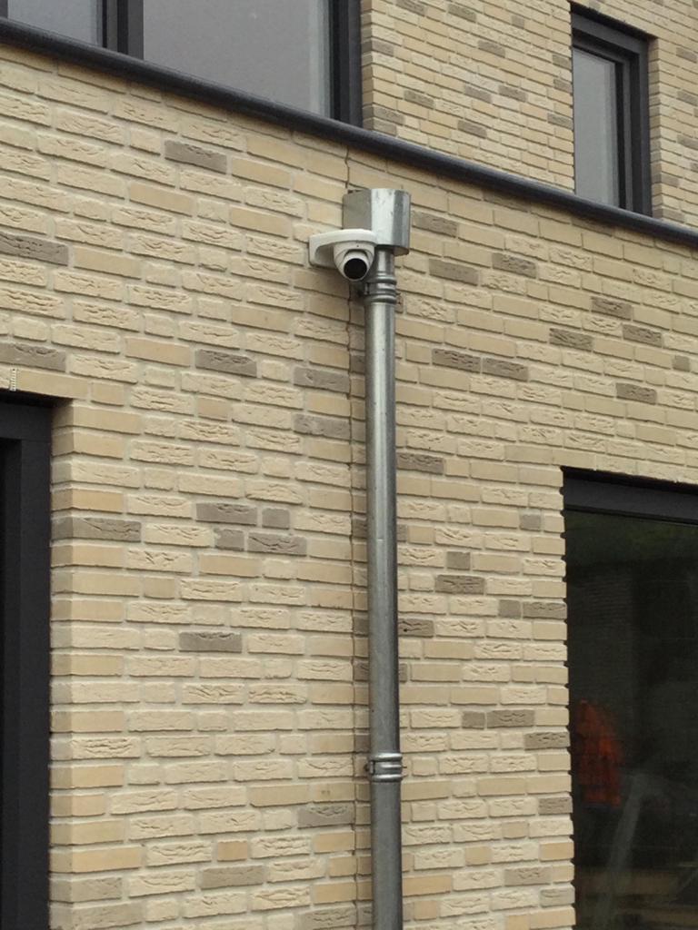 Witte camera met kabelbuis strak langs de gevel weggewerkt