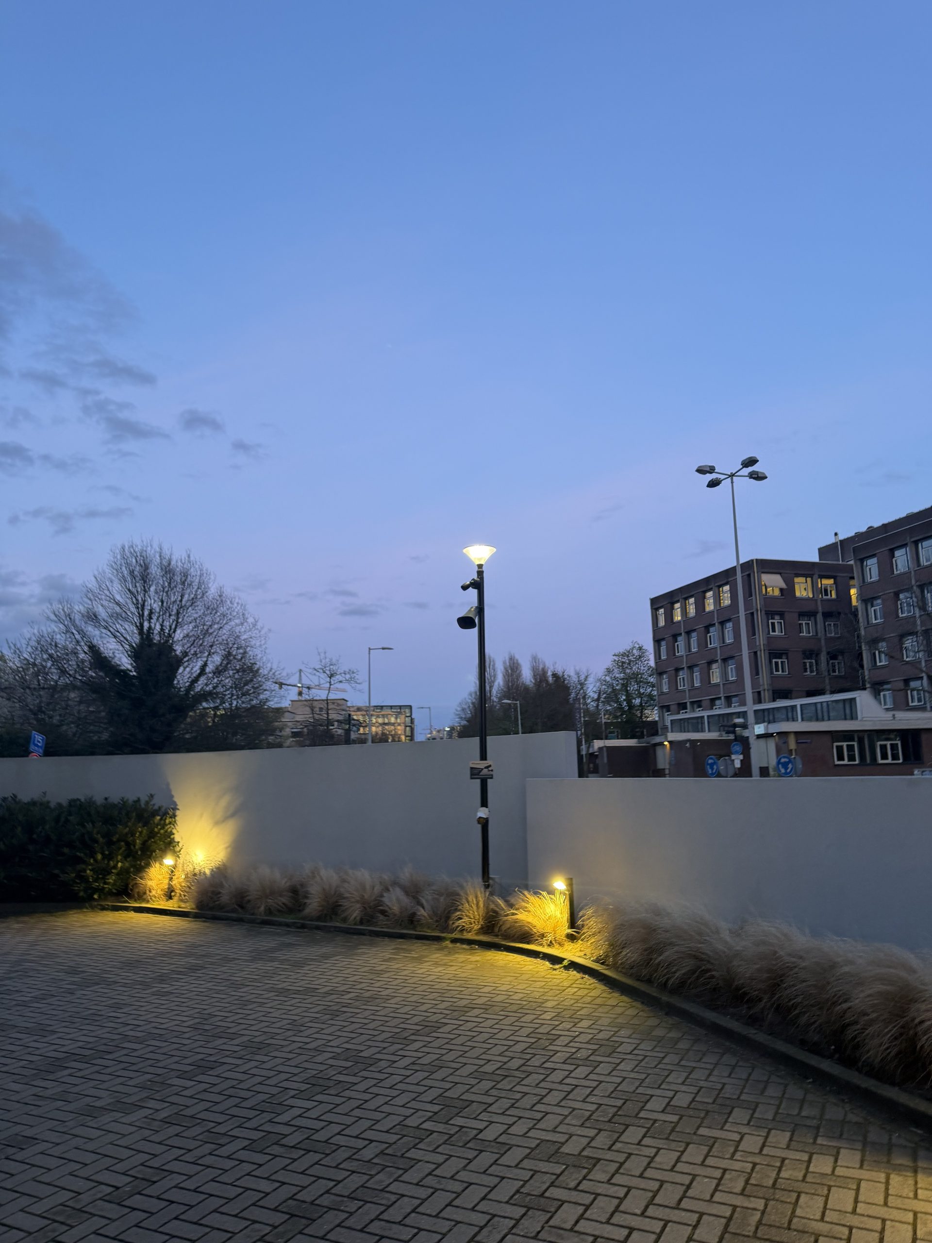 Beveiligingscamera en luidspreker samen op een lichtmast bij het hotelparkeerterrein in Amsterdam