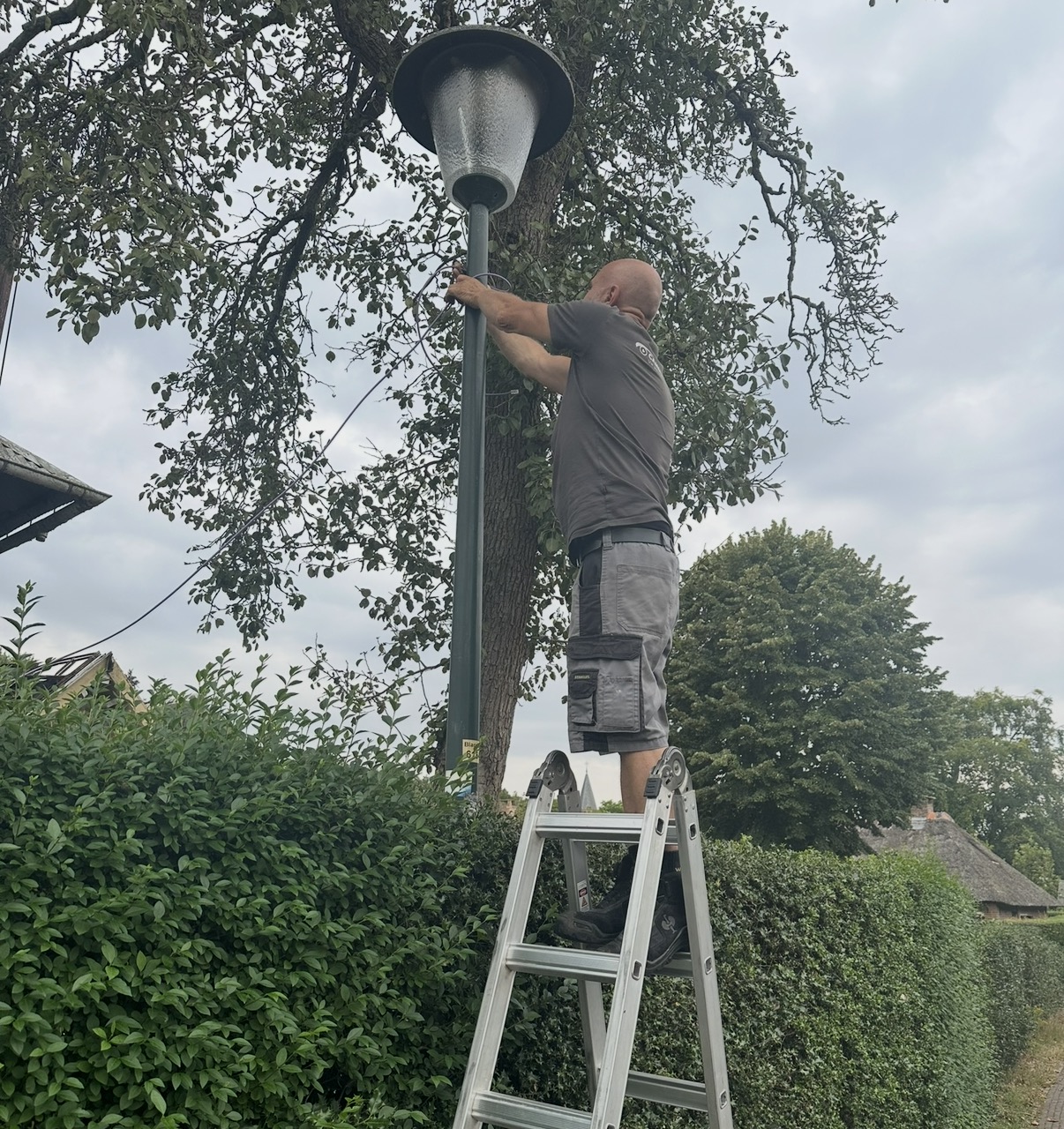 Monteur installeert een tijdelijke beveiligingscamera op een lantaarnpaal in Blaricum