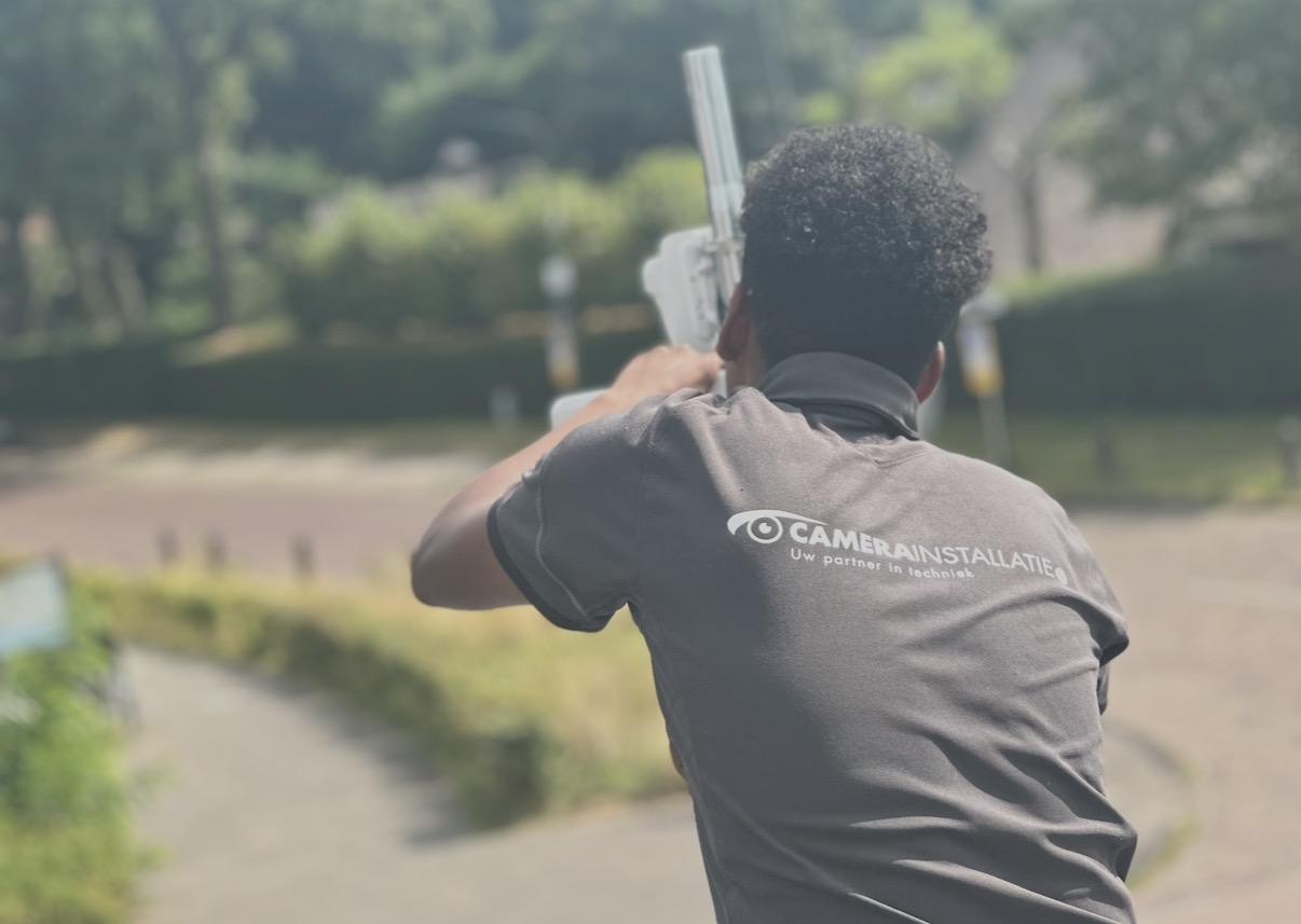 Monteur van CameraInstallatie.nl richt een camera langs de route van de Blaricumse kermis
