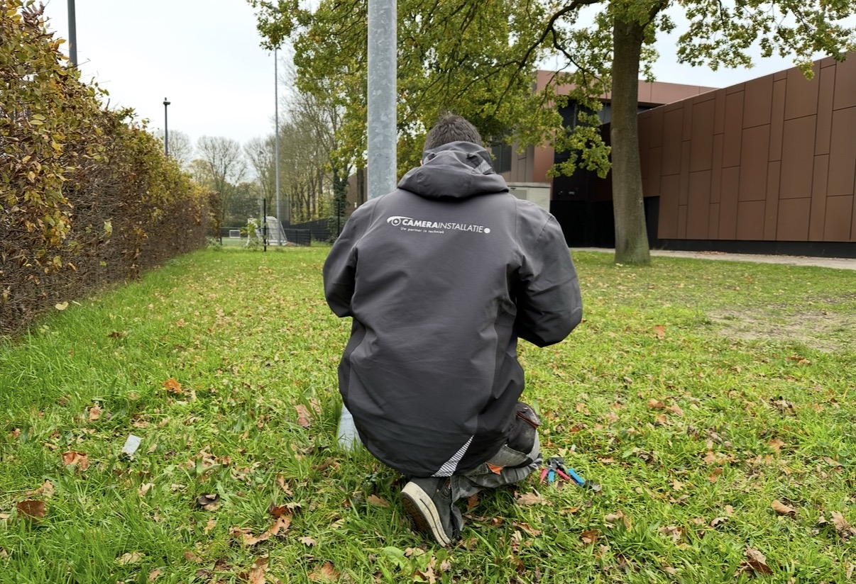 Monteur van CameraInstallatie.nl plaatst een camera in de openbare ruimte bij de sportvelden in Eemnes
