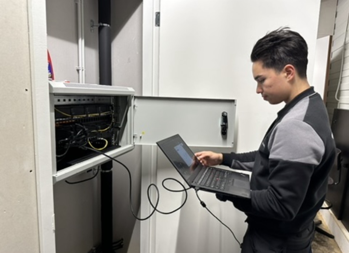 Monteur configureert een technische kast met glasvezel- en netwerkapparatuur voor de gemeente Eemnes