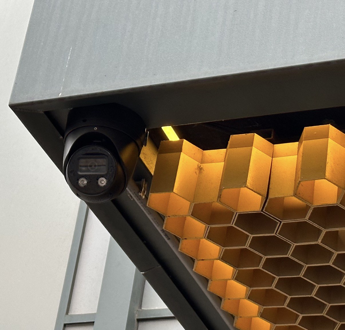 Een camera onder de luifel, direct naast het gouden honingraatplafond van de entree