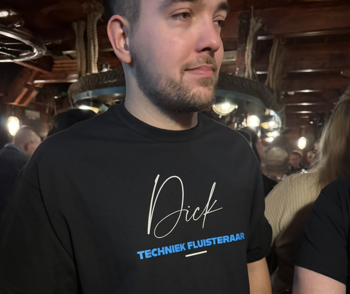 Dick tussen de collega's, met zijn shirt aan