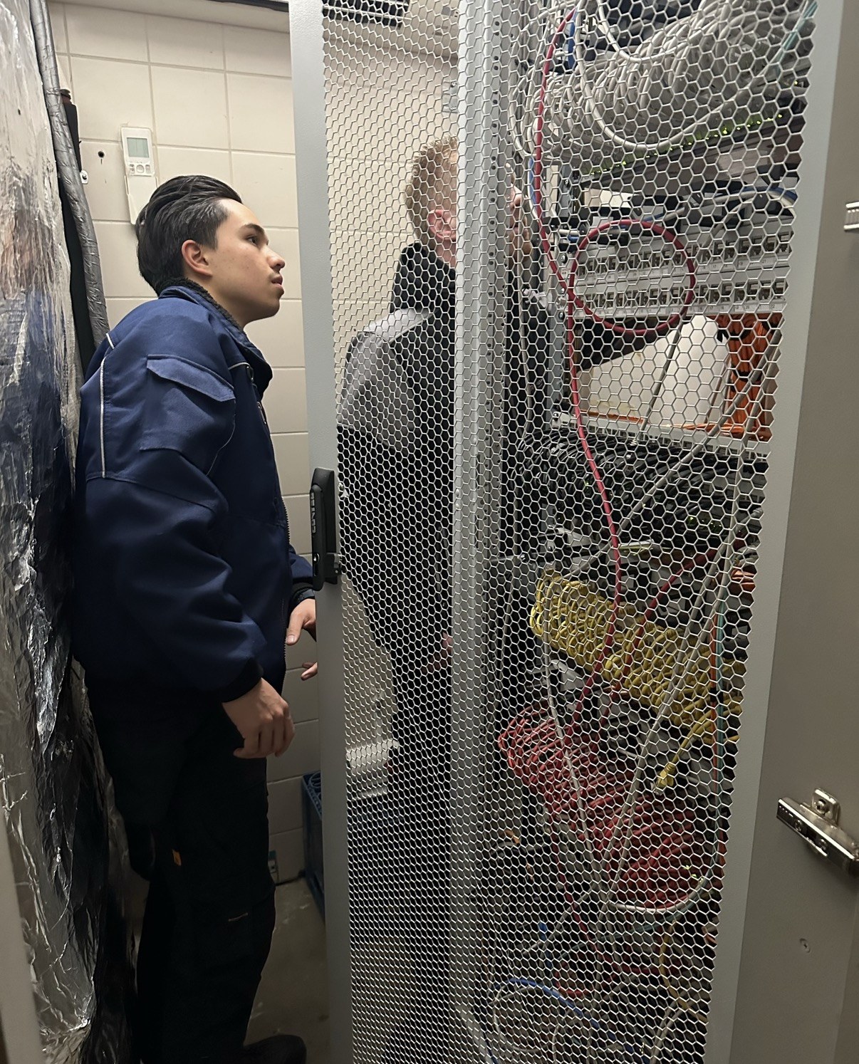 In de technische ruimte: de serverkast open, met de patchkabels en apparatuur in beeld
