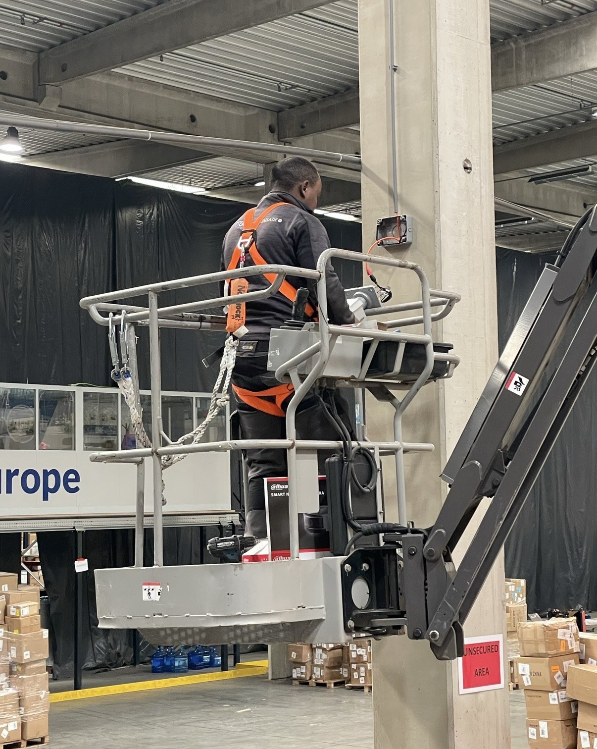 Vanuit de hoogwerker de aansluitdoos plaatsen aan de betonkolom