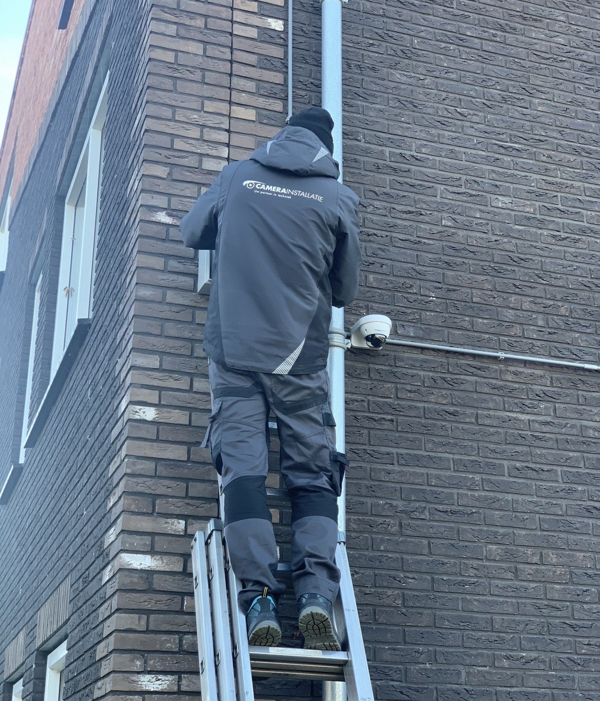 Aan de schuurzijde: camera monteren met de kabel netjes in de buis