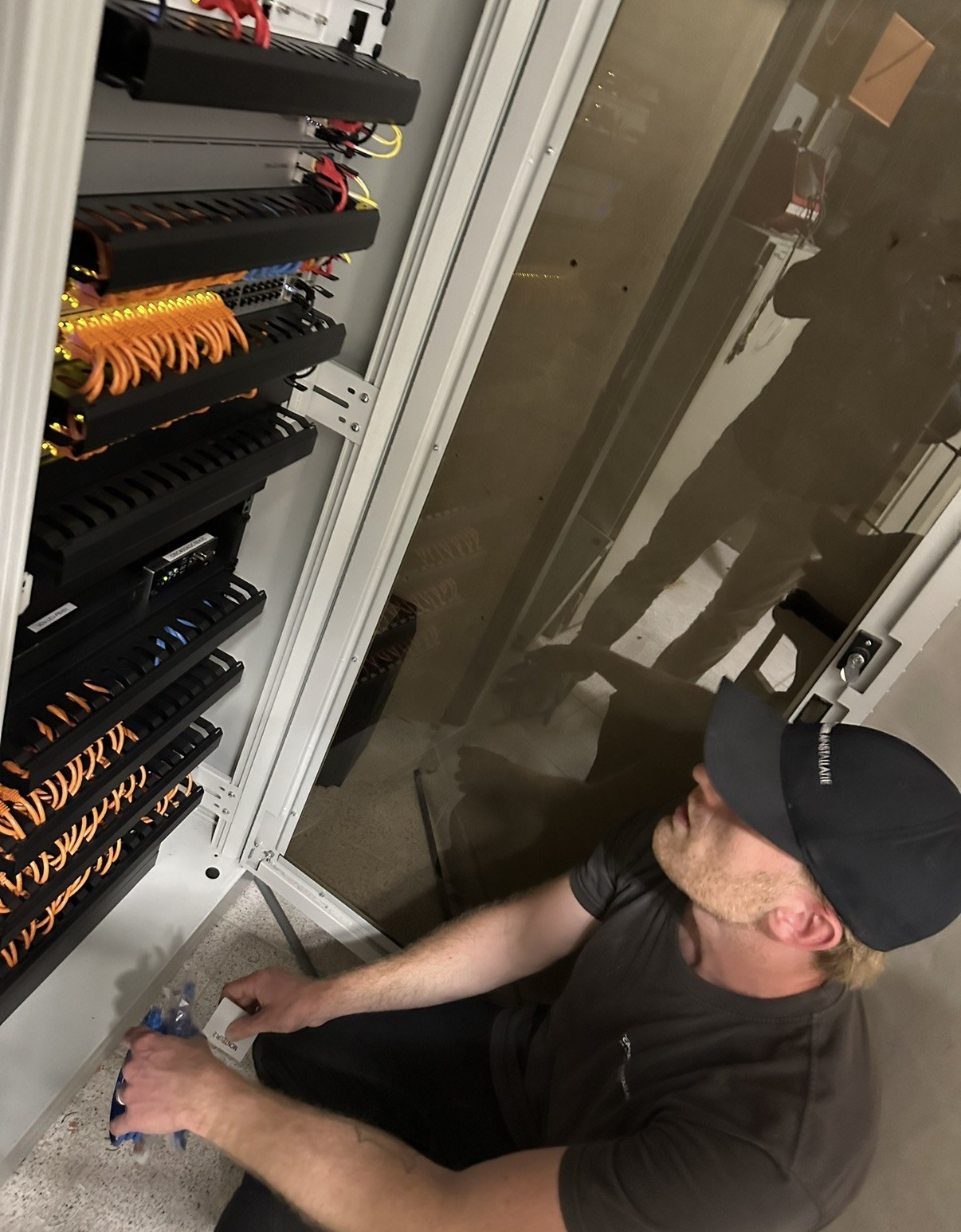 Onze monteur werkt in de kast en labelt de aansluitingen