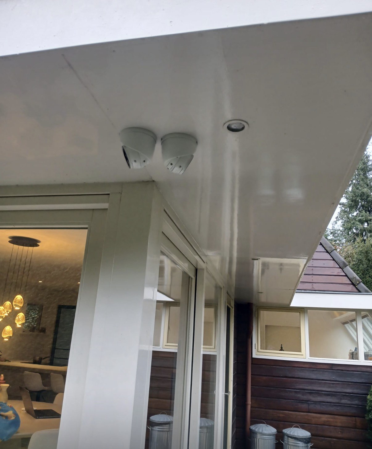 Twee camera’s netjes onder de overkapping van een woning gemonteerd, zonder zichtbare kabels