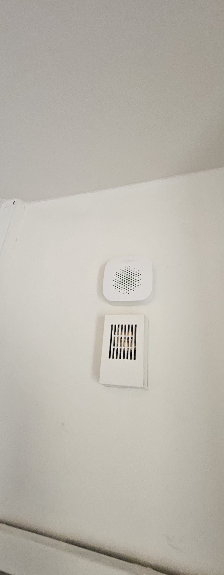 Draadloze Dahua binnensirene netjes wit op wit gemonteerd in de hoek van de woning