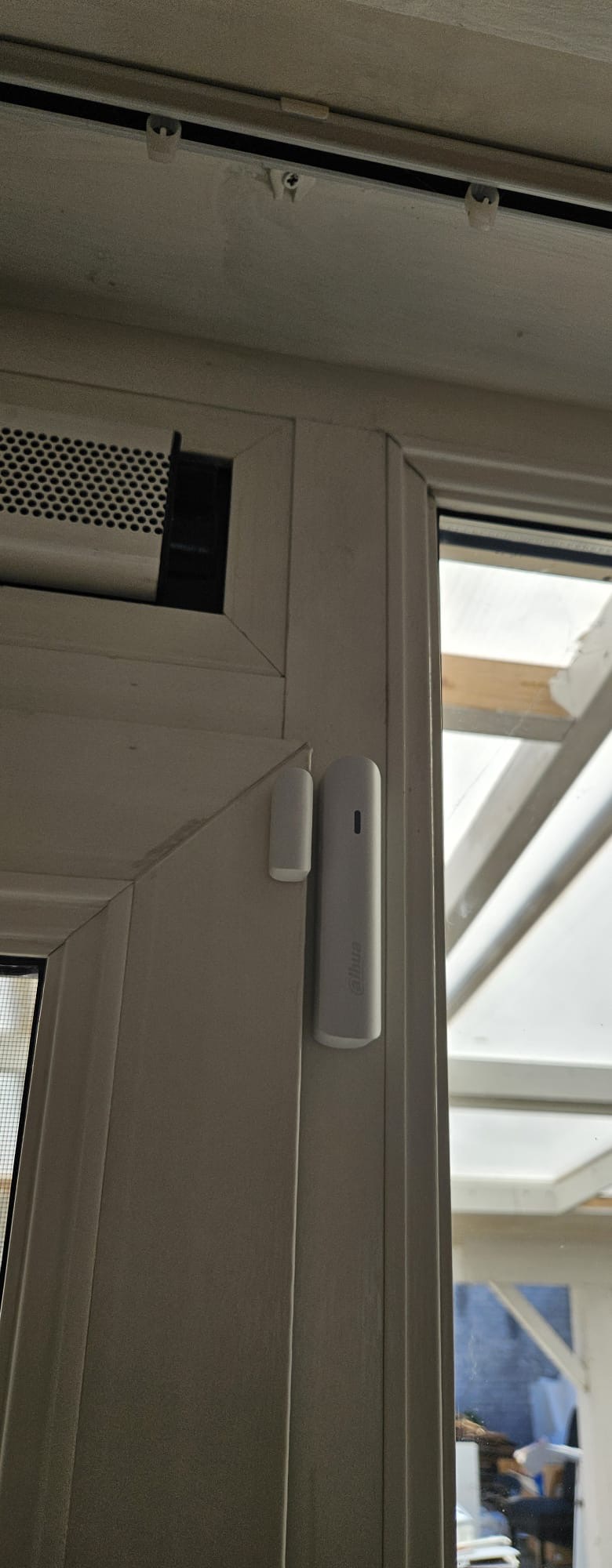 Draadloos Dahua deur- en raamcontact gemonteerd op een deur in de serre van de woning