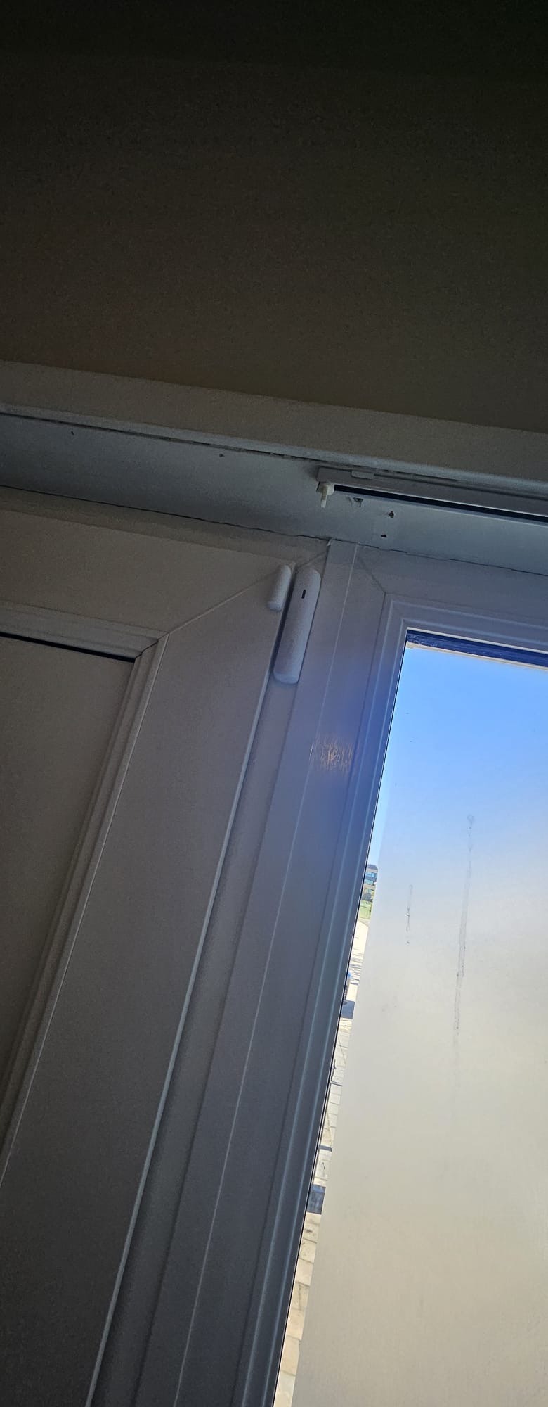 Wit draadloos deur- en raamcontact netjes afgestemd op het witte kozijn van de woning