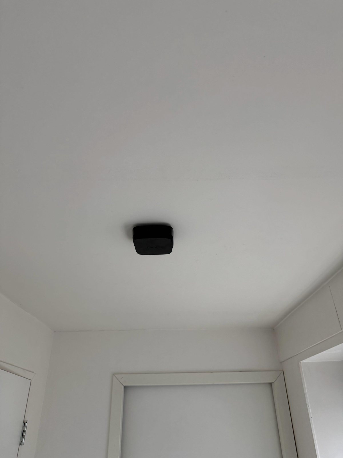 Draadloze melder onopvallend aan het plafond van een woning gemonteerd
