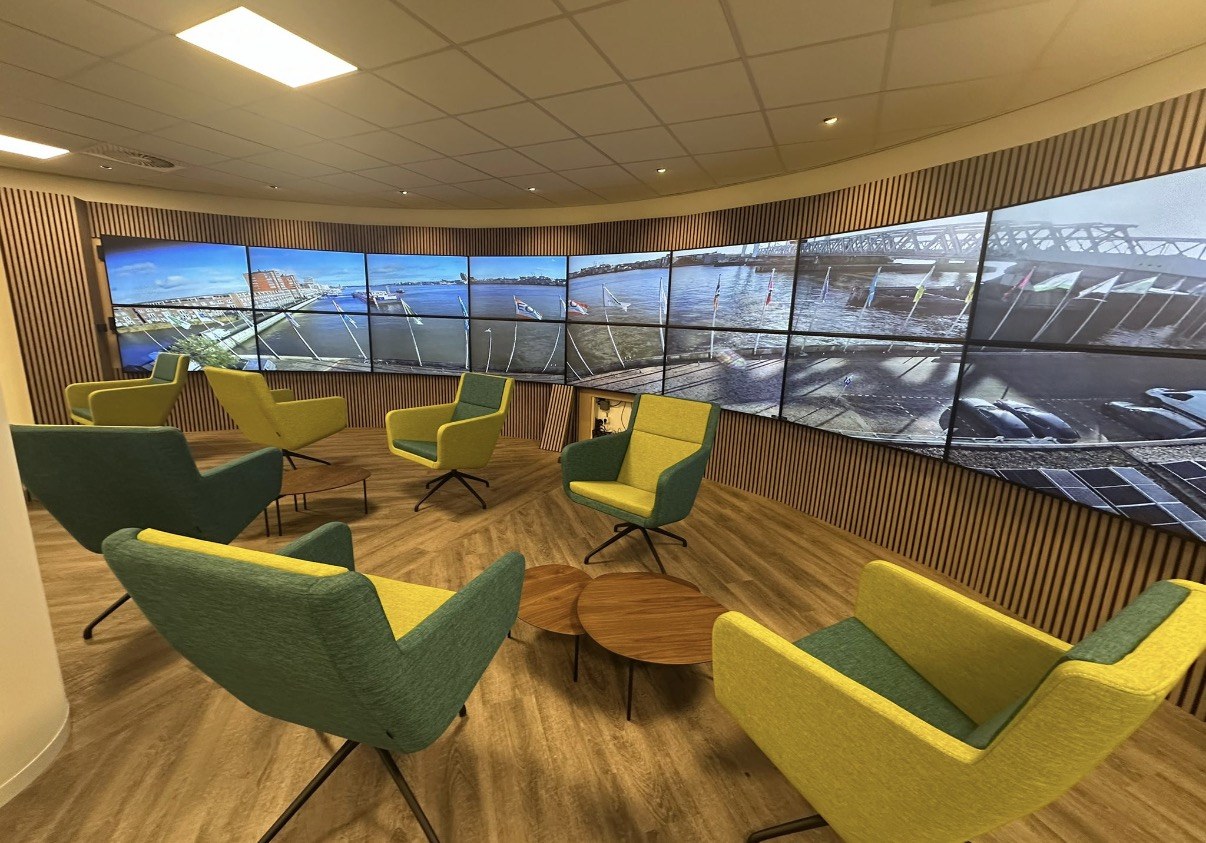 Gebogen videowall met live camerabeeld van de haven in een vergaderzaal