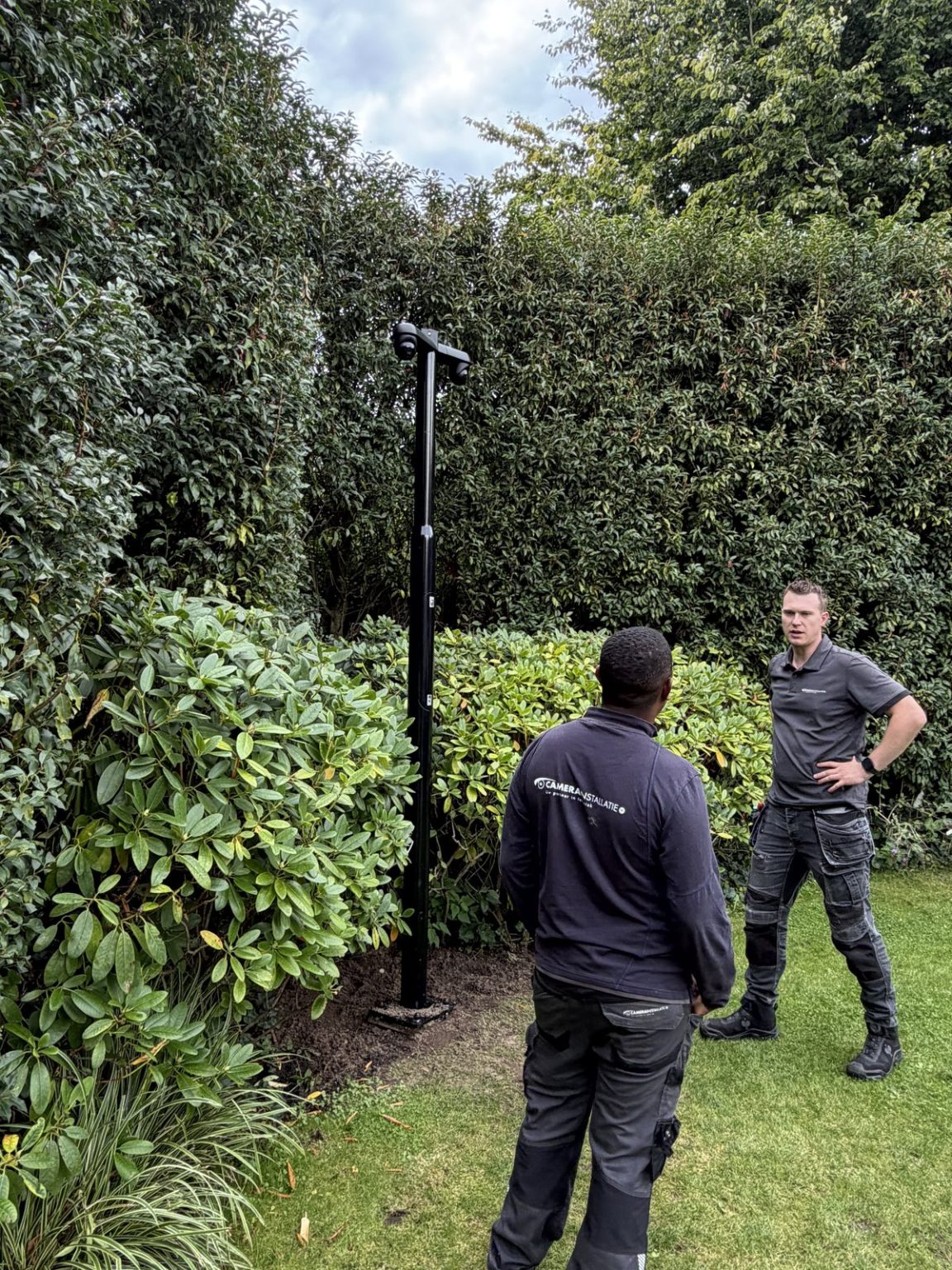 Monteurs van CameraInstallatie bij een cameramast in de tuin