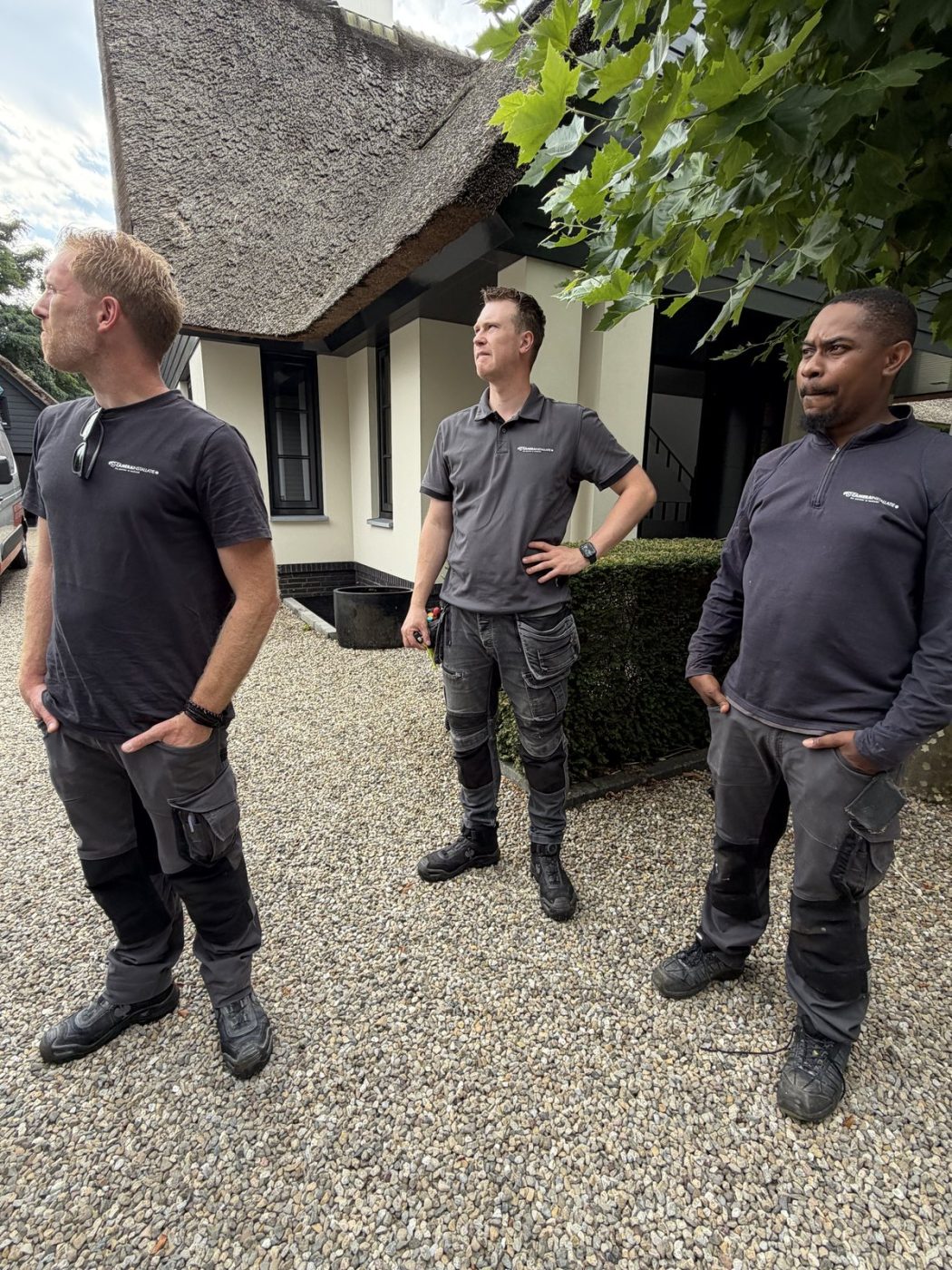 Drie monteurs van CameraInstallatie voor de rietgedekte villa in Blaricum
