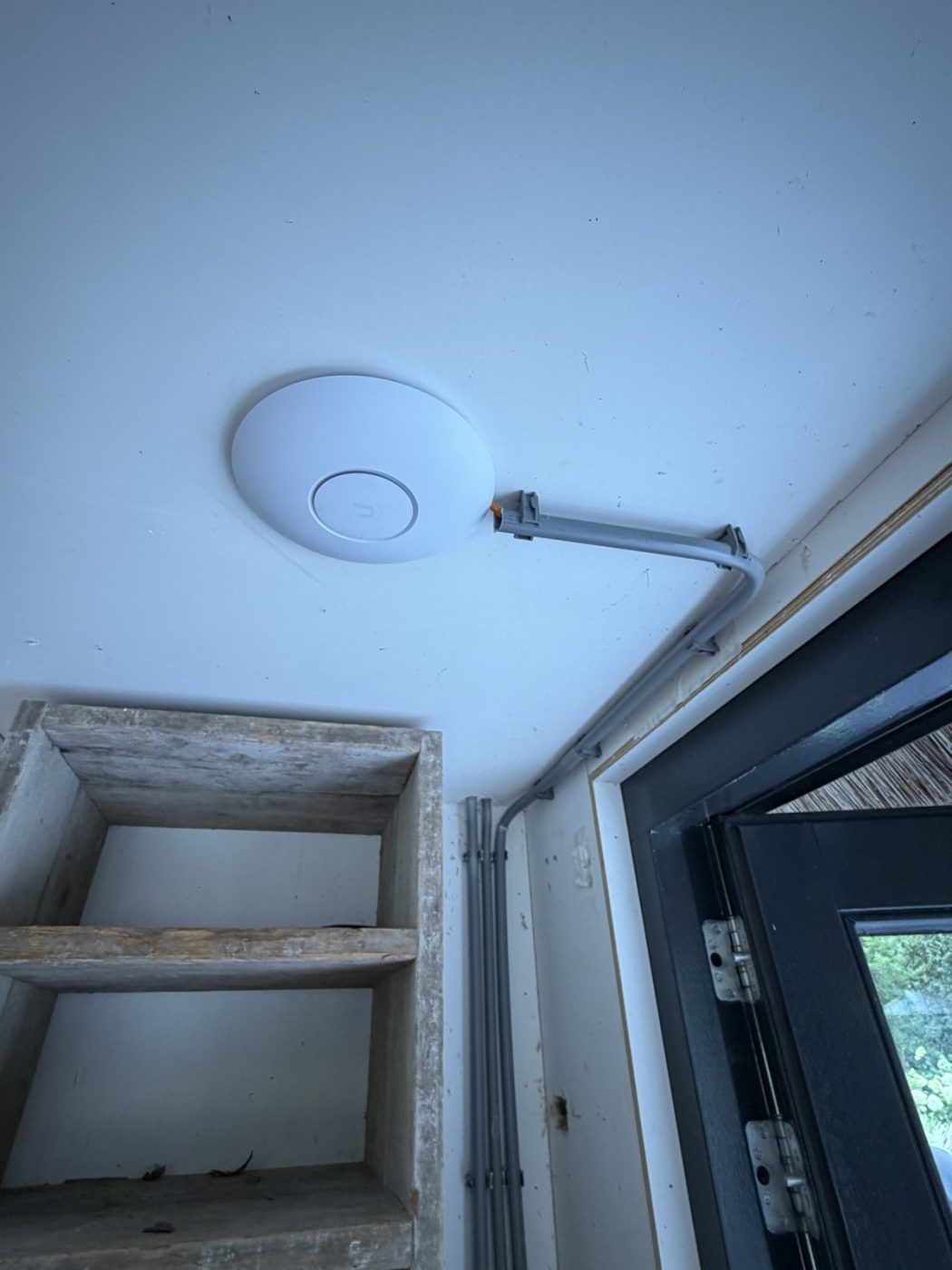 Wifi-accesspoint aan de binnenmuur, met de netwerkkabel netjes in opbouwleiding weggewerkt