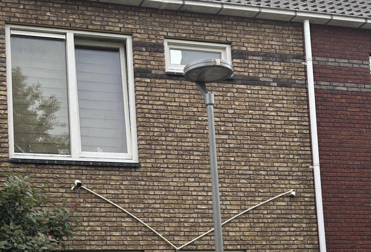 Voorbeeld van zichtbaar en slordig over de gevel gespannen camerakabels, hoe je het juist niet wilt (niet door ons geplaatst)