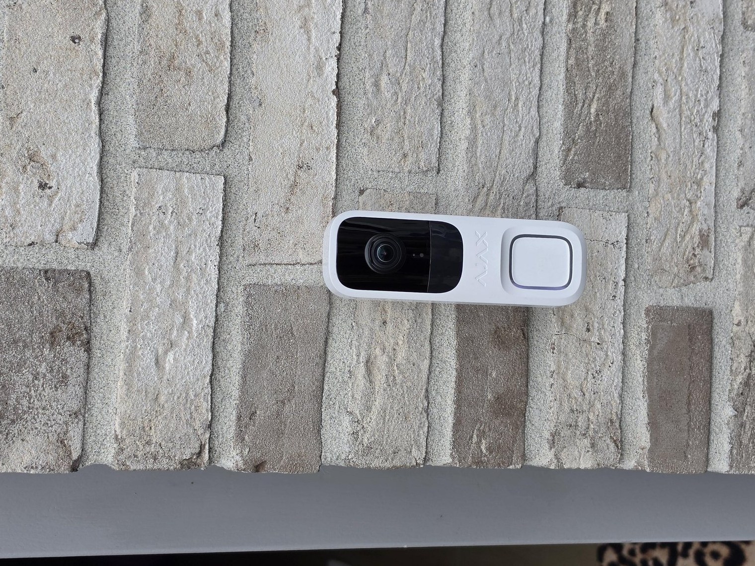 Metalen bord camerabewaking van CameraInstallatie.nl op een bakstenen pilaar bij de ingang