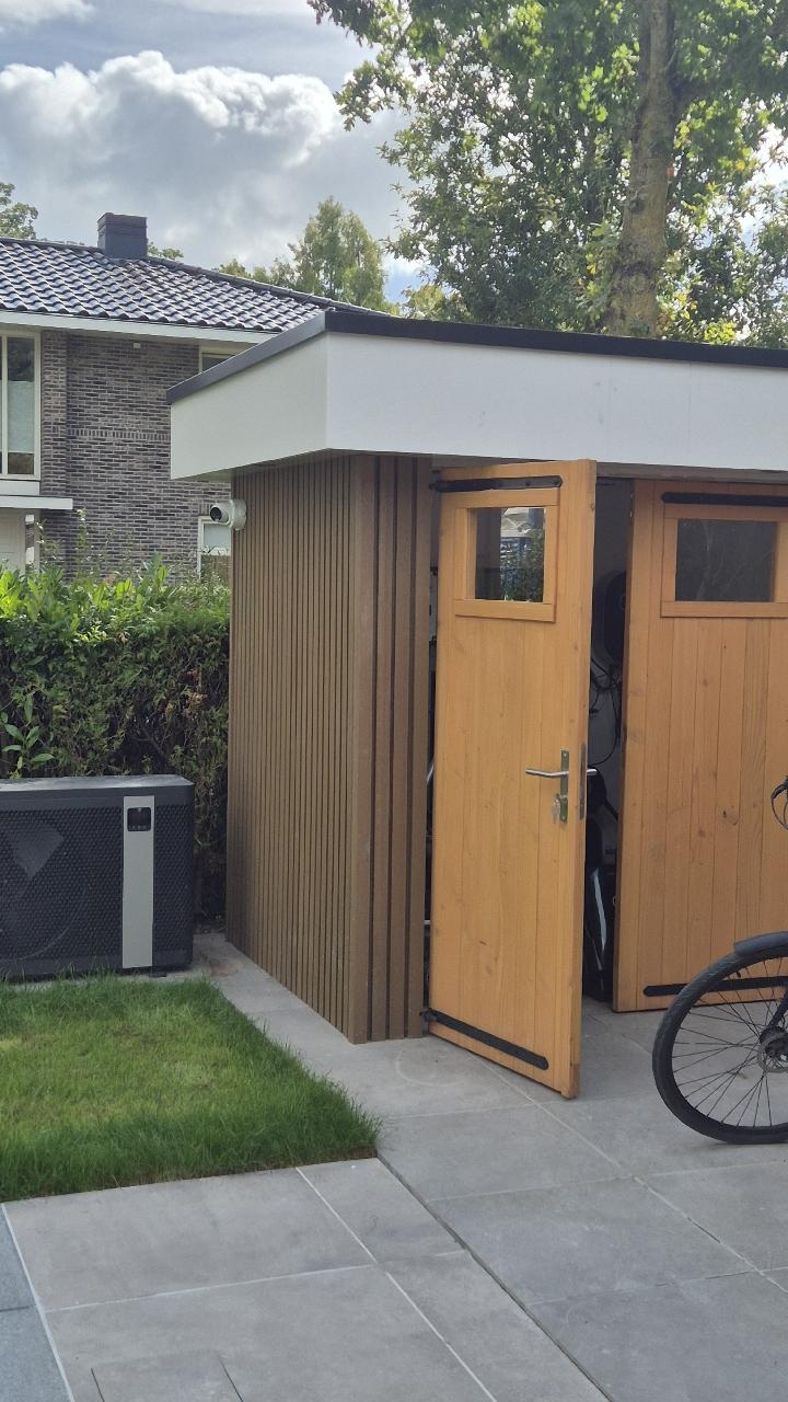 Camera aan de gevel van de woning met zicht op de berging en het terras