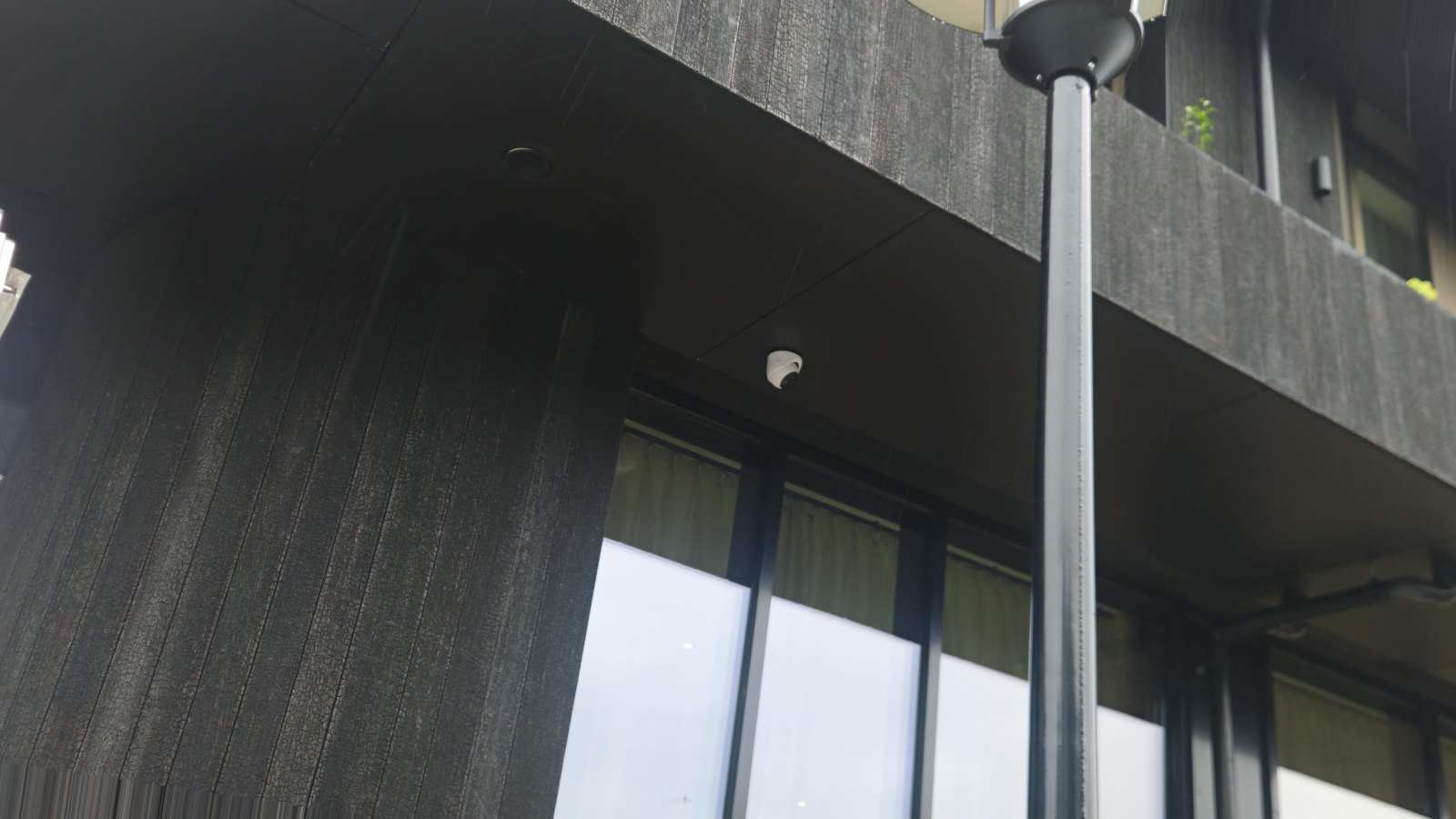 Camera onder de uitkragende verdieping bij de hoofdentree van het hotel