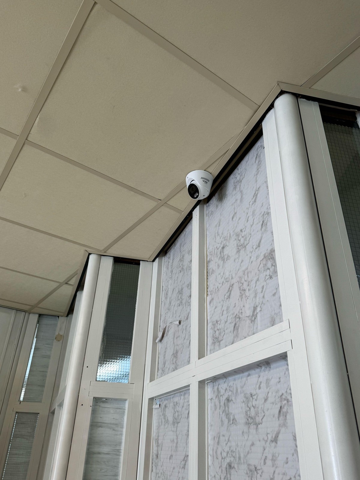 Camera onder het plafond bij een glazen scheidingswand