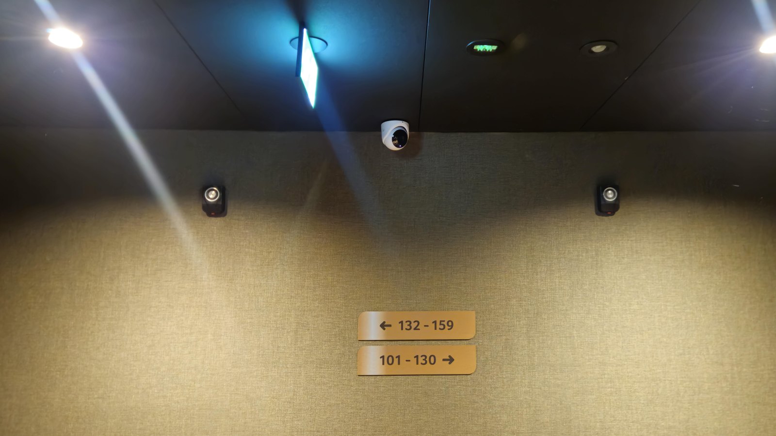 Domecamera in de hotelgang boven de bordjes met kamernummers