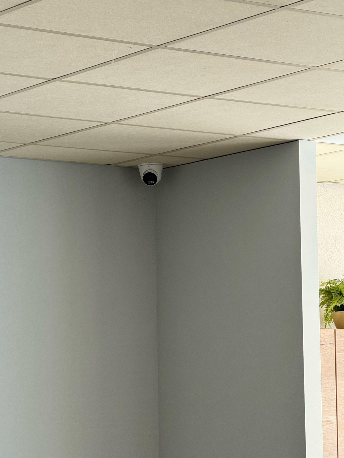 Camera in de hoek van een ruimte, met zicht op de doorgang