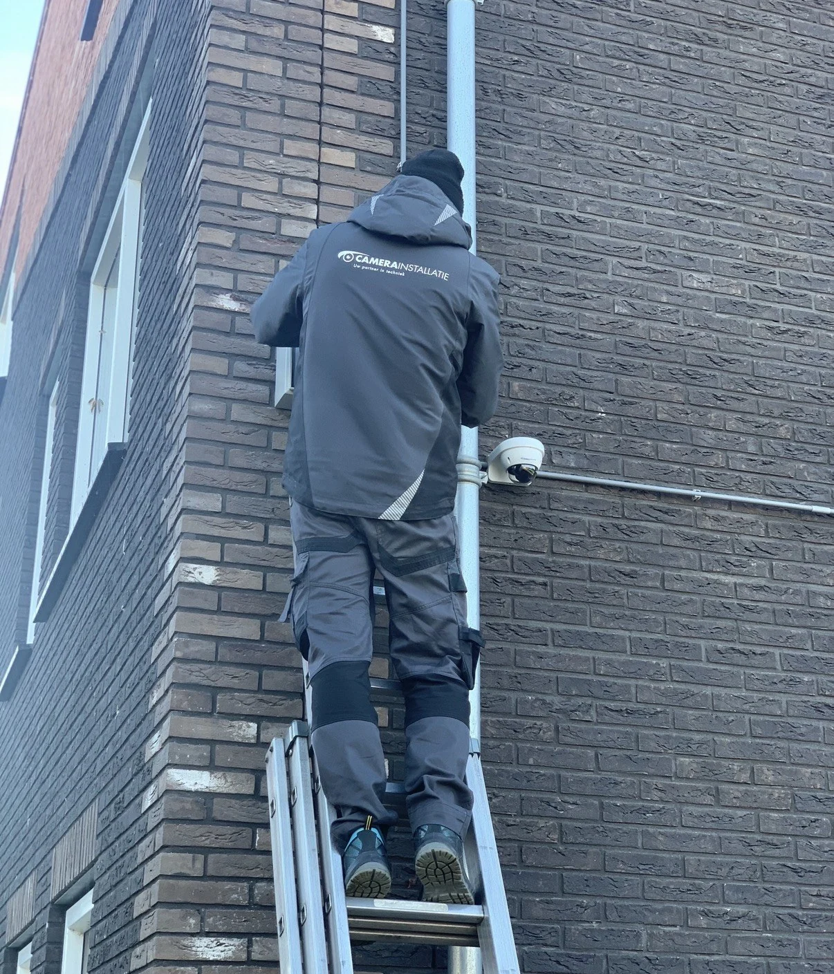 Aan de schuurzijde: camera monteren met de kabel netjes in de buis