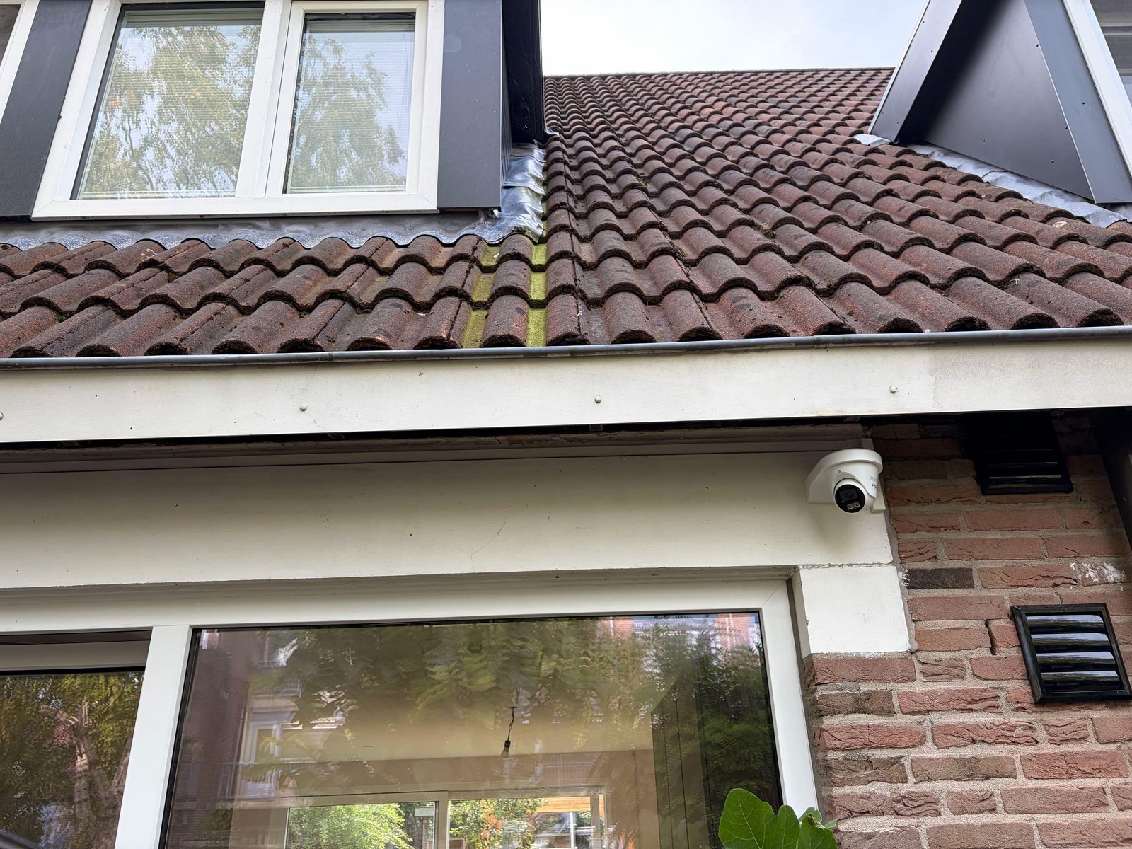 Witte VIGI-camera van 8 megapixel onder de dakrand, boven de tuindeuren van een woning in Vinkeveen