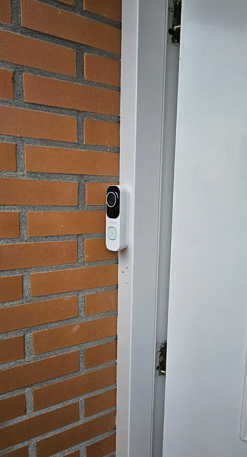 Metalen bord camerabewaking van CameraInstallatie.nl op een bakstenen pilaar bij de ingang