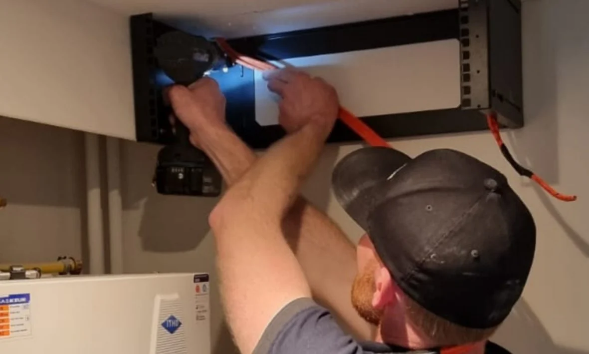 Monteur van CameraInstallatie plaatst de recorder in de technische kast