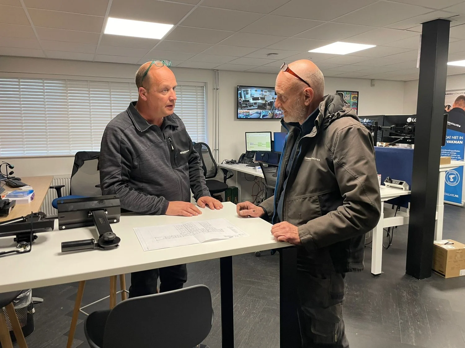 Het team bespreekt op kantoor de tekening van een zakelijke installatie