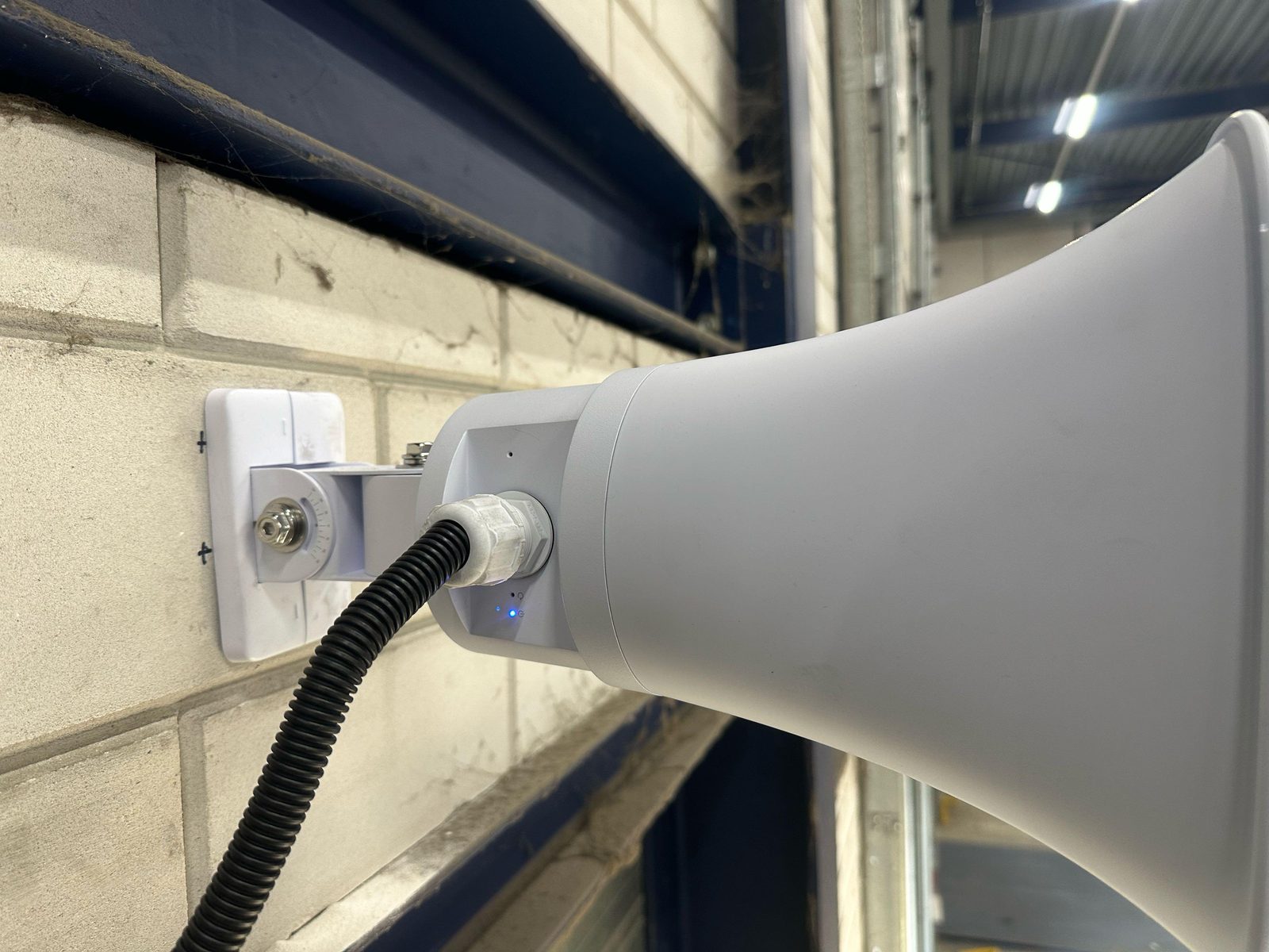 Metalen bord camerabewaking van CameraInstallatie.nl op een bakstenen pilaar bij de ingang