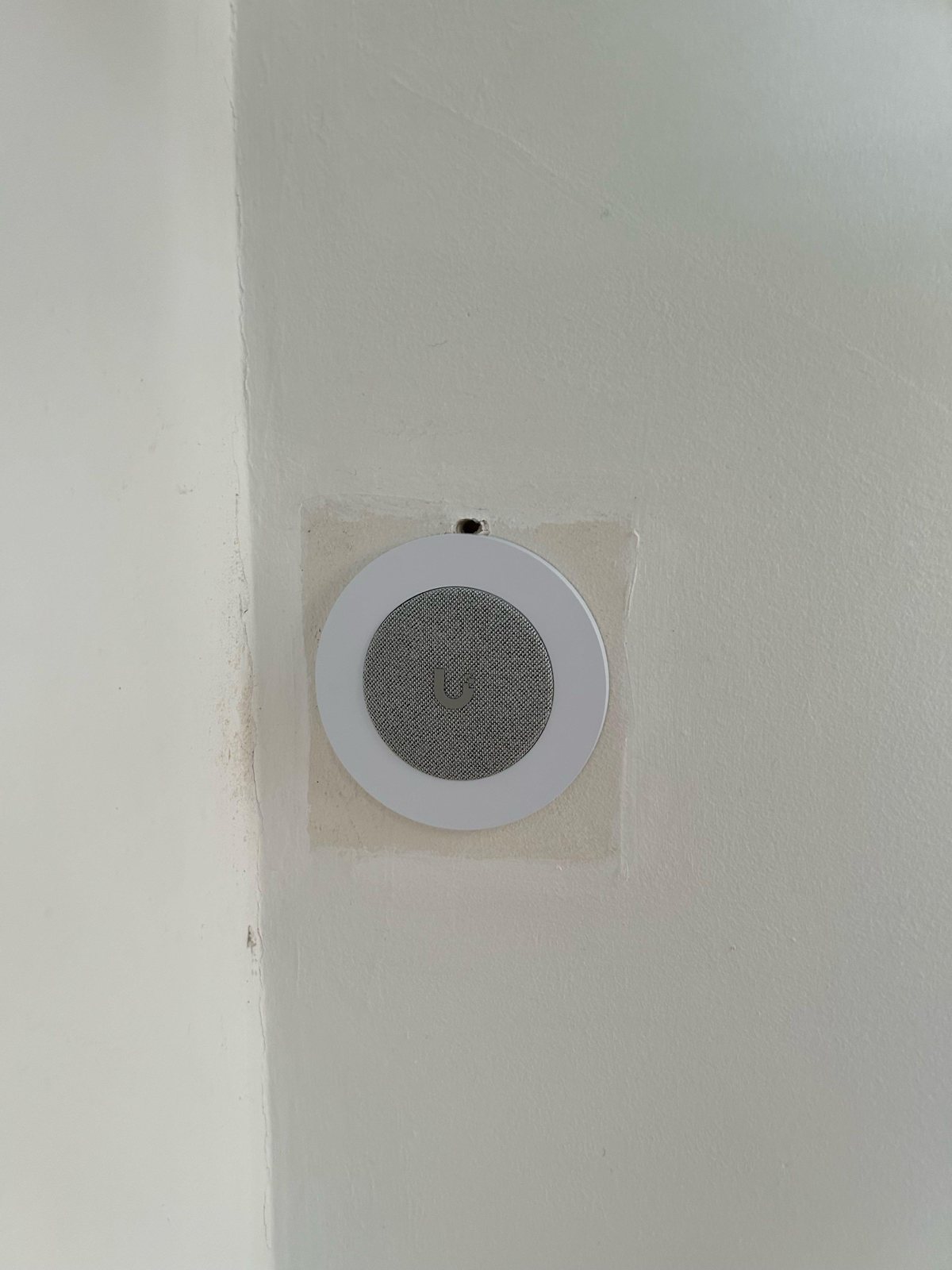 UniFi PoE-gong ingebouwd in de wand, met de lichte rand van de oude gong eromheen