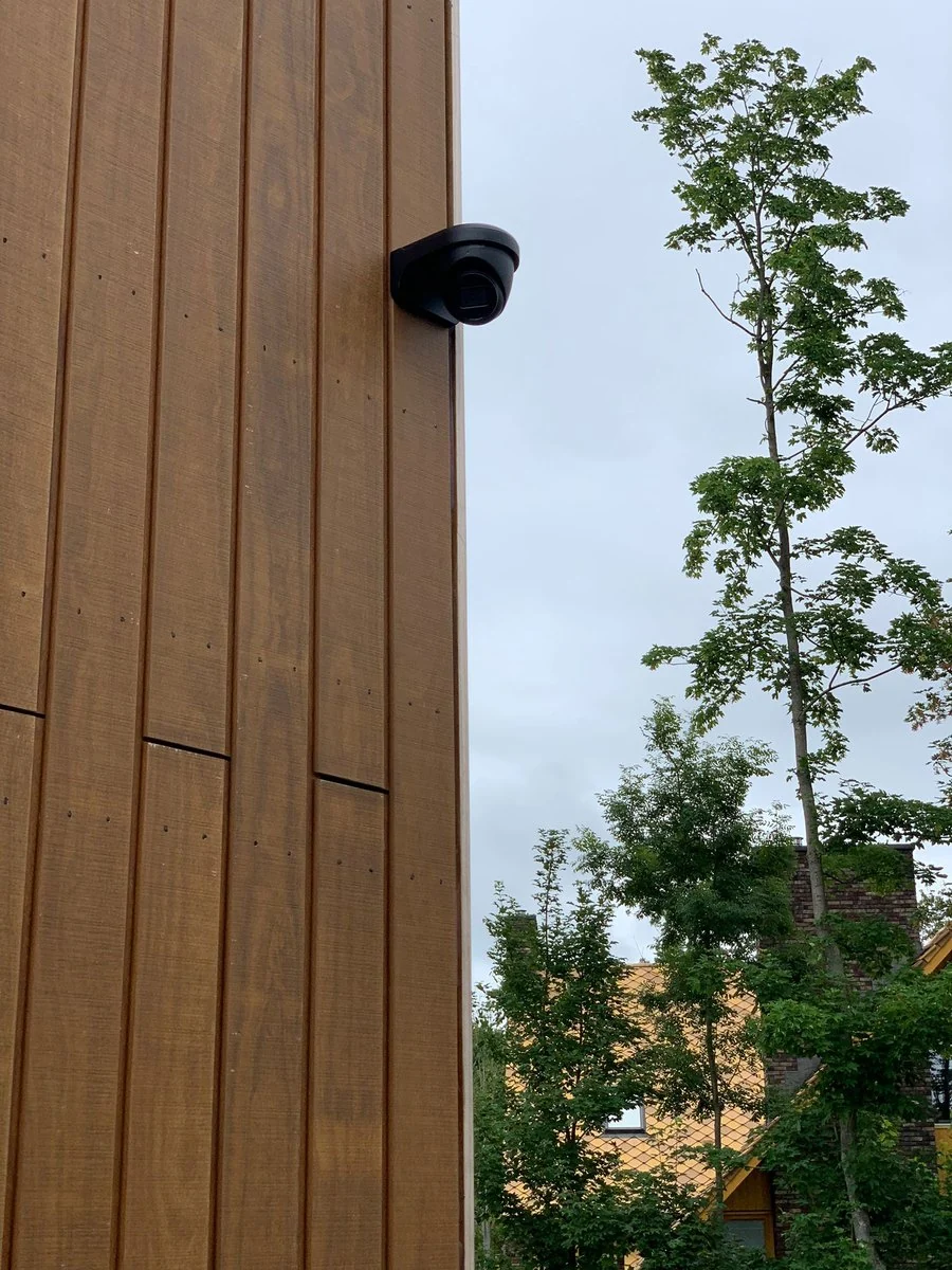 Zwarte camera op een houten gevel