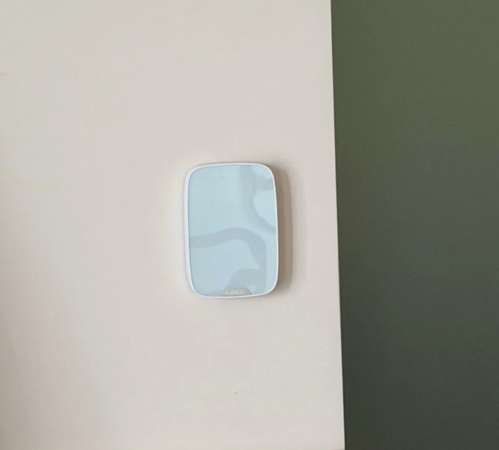 Wit Ajax-keypad op een lichte wand naast een groene muur, in Kropswolde