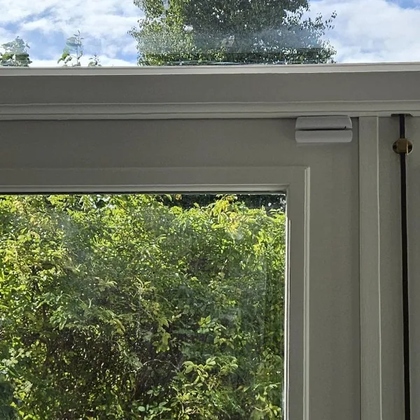 Openslaande tuindeuren met bovenop een klein wit Ajax-magneetcontact, bij een woning in Amsterdam (eigen werk)