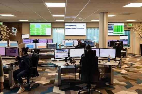 Werkplekken met meerdere schermen in de meldkamer van Alarm Meldnet