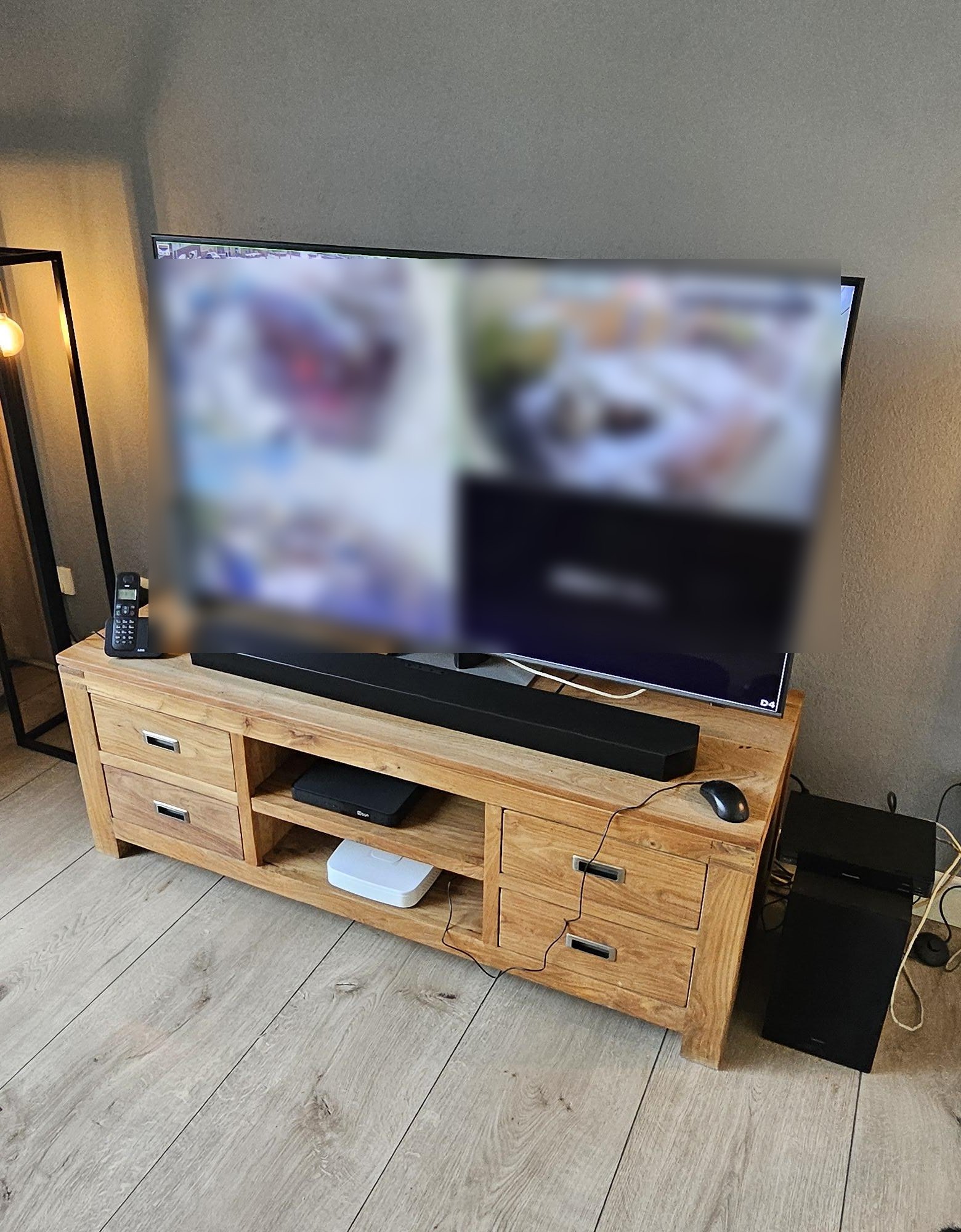 Tv op een houten meubel in de woonkamer met de camerabeelden in vier vakken, onscherp gemaakt