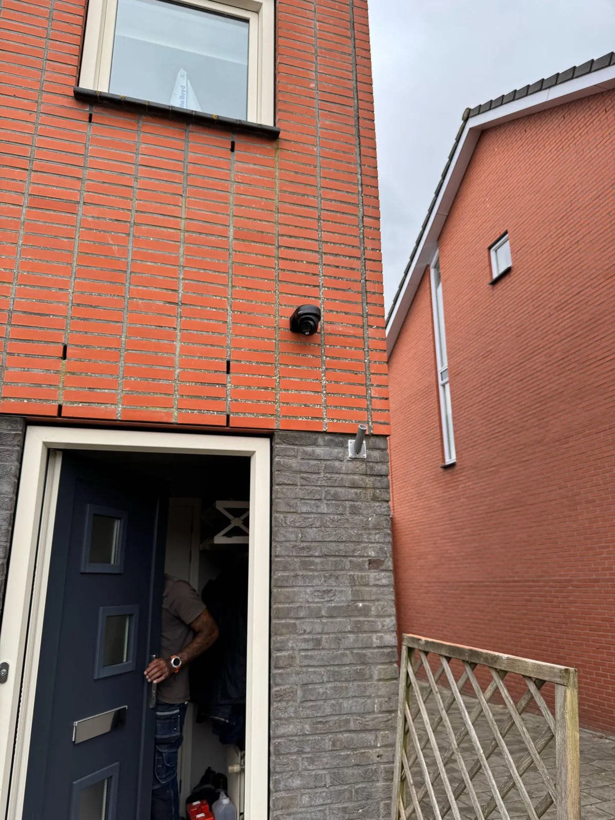 Zwarte Dahua-turretcamera van 8 MP boven de voordeur van een hoekwoning in Purmerend, met de steeg ernaast