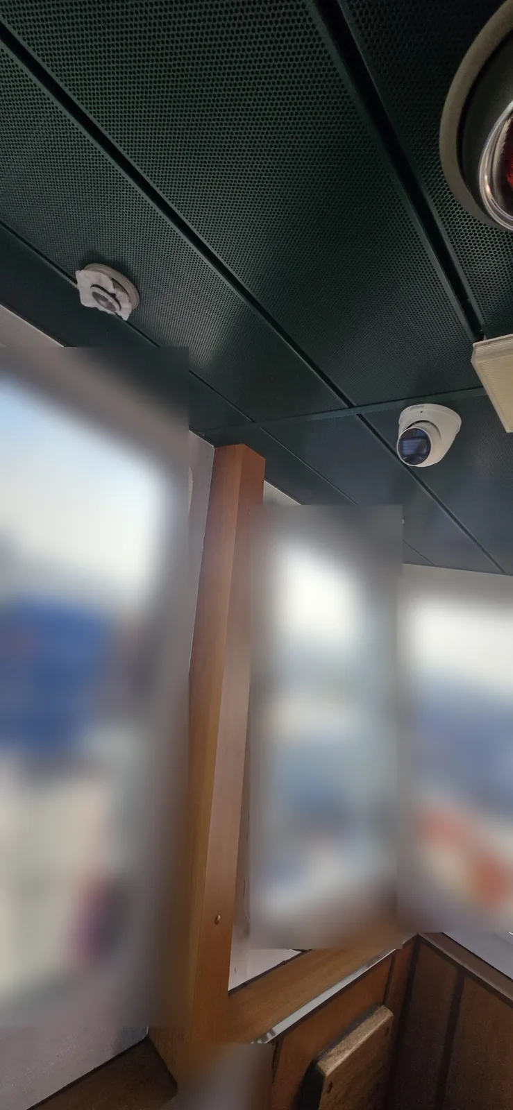 Witte Dahua-camera in de hoek van het stuurhutplafond, boven de ramen van een containerschip in Moerdijk