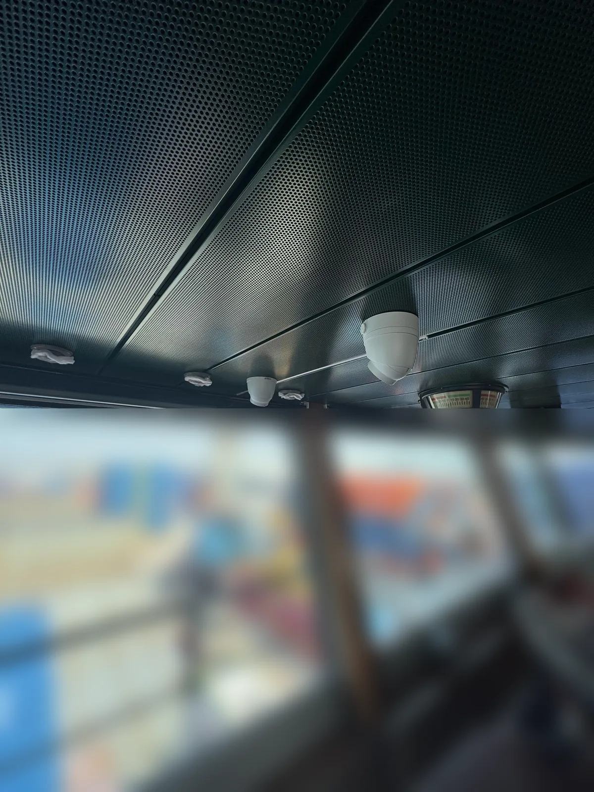 Witte Dahua-camera aan een plafondbeugel boven de ramen van de stuurhut, naast een instrument tegen het plafond
