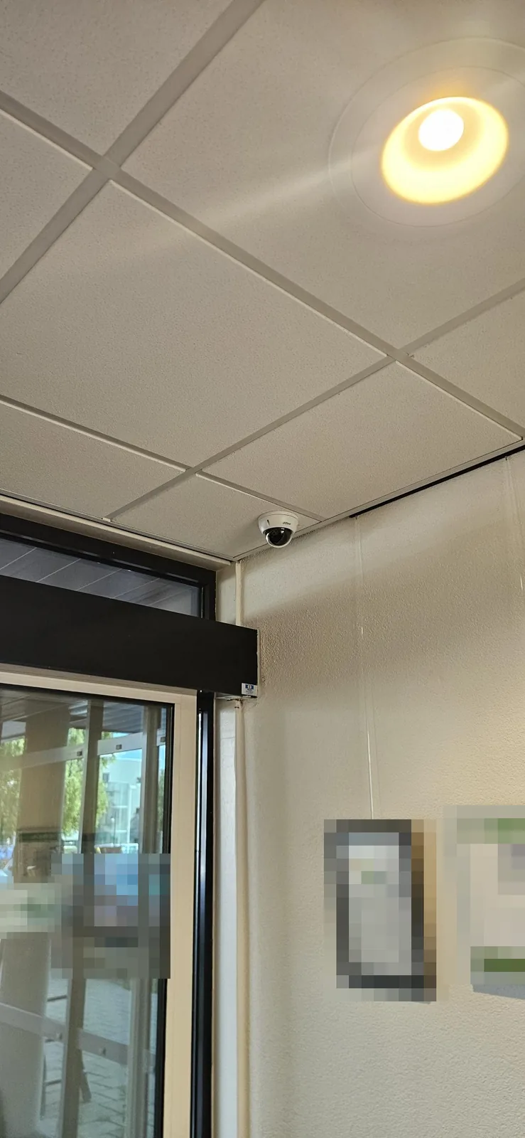 Witte Dahua-domecamera van 8 MP aan het systeemplafond van de hal