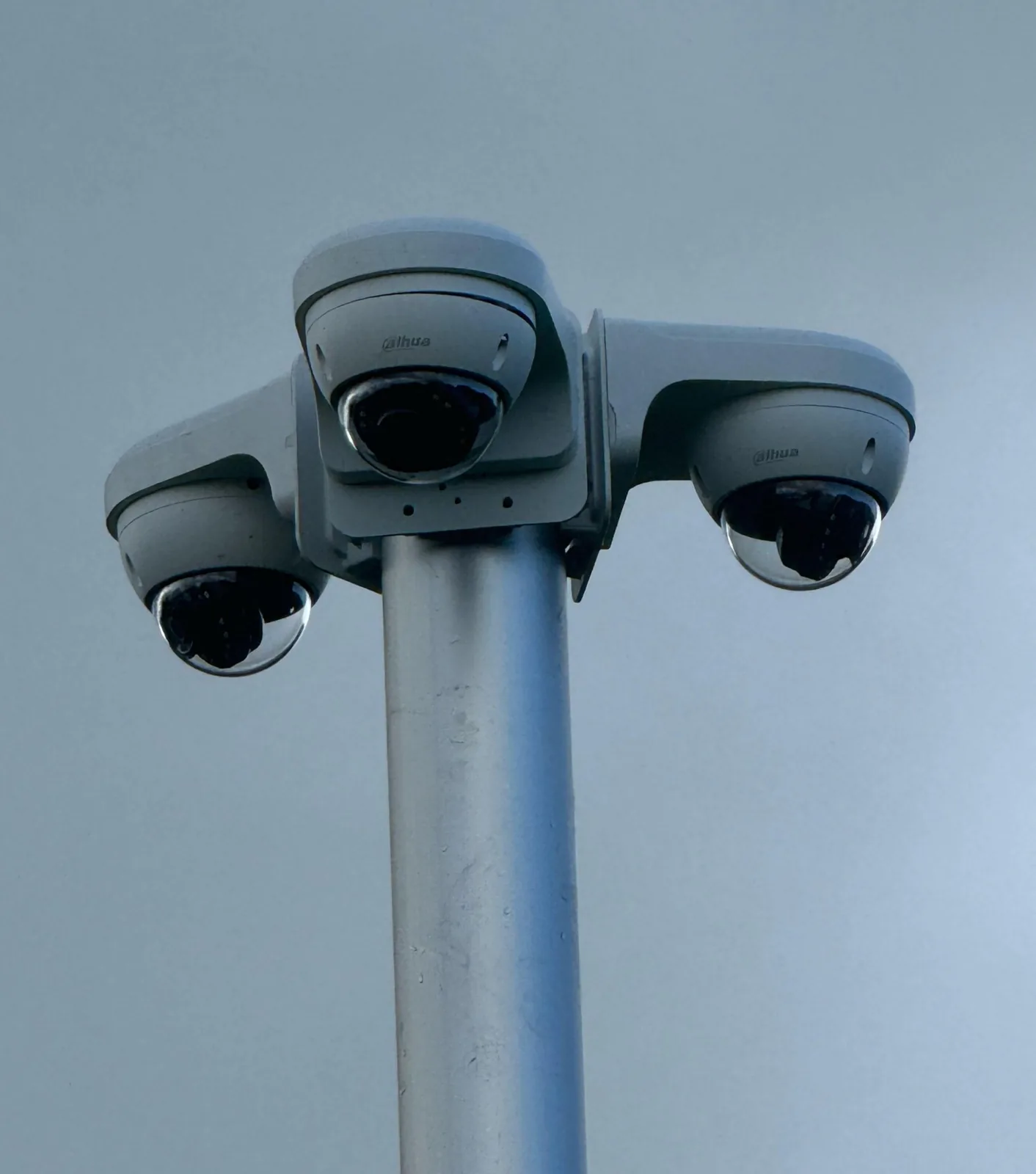 Drie Dahua-camera's op een driedubbele beugel bovenin een grijze camerapaal